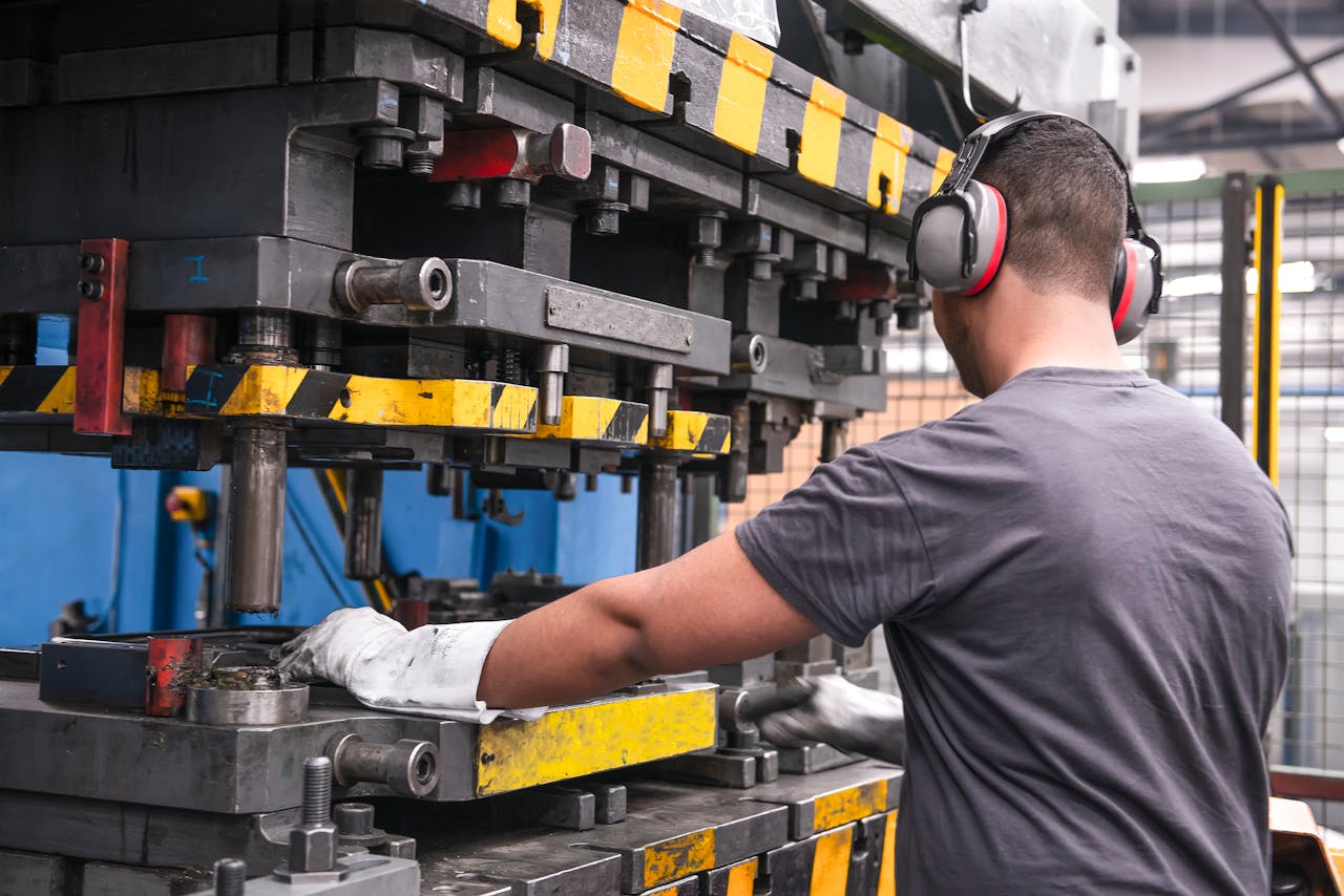 Man wearing ear defenders whilst using a machine